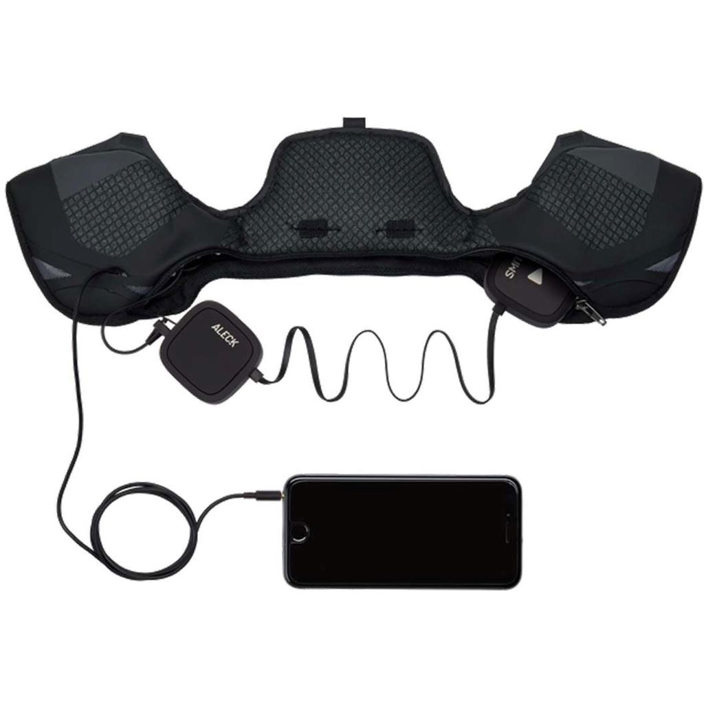 A pair of black, round wireless helmet audio chips placed next to the audio-ready earpad of a Smith Vantage ski helmet