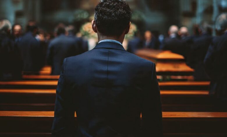 Person wearing dark navy suit at funeral service as respectful alternative to black attire