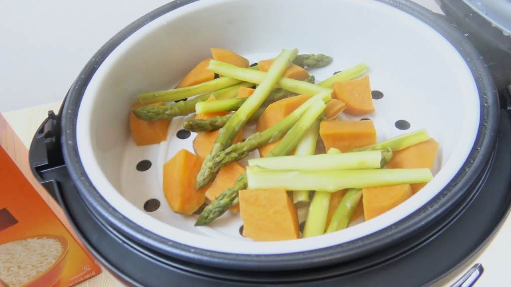 Versatile steaming tray in Aroma rice cooker preparing vegetables and rice together.