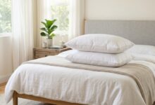 Plush white down pillow stacked on a supportive feather pillow on a cozy bed.